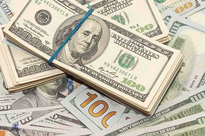 shutterstock_1685191720 Stack of US hundred-dollar bills bound with a blue band