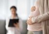 Surrogacy Shock: Lawmakers Caught Off-Guard Pregnant woman holding belly during medical visit