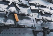 Undercover Sting Stops AK-47 Massacre Assault rifles displayed on a perforated wall