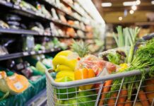 Backlash Explodes Over Israel-Grocery Ad shopping cart filled with fresh produce in a grocery store aisle