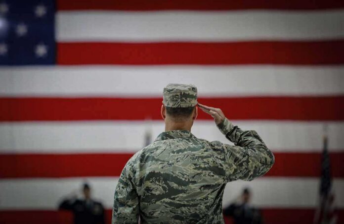Soldier saluting before a large American flag