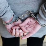 person in handcuffs with hands behind back