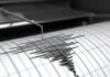 Seismograph needle recording earthquake waves on paper