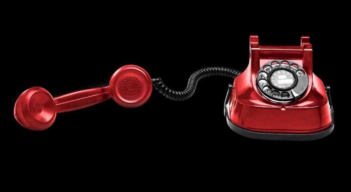 Red rotary dial telephone with handset off the hook