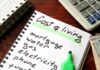 Budget notebook with cost of living list, calculator, and cash