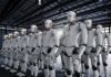 Rows of humanoid robots standing in a warehouse